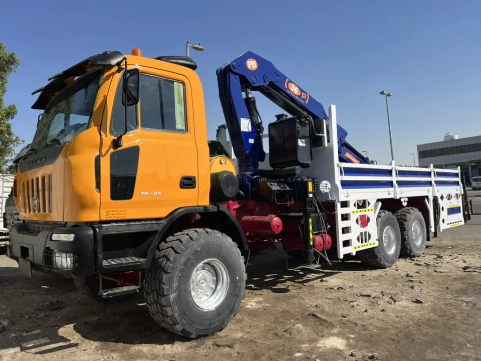 Pole Star orange Astra 6×6 crane truck with wide off-road tyres and a PM knuckle-boom crane.