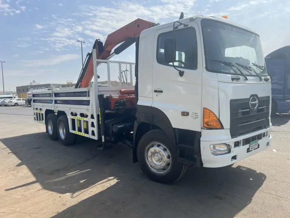 Pole Star white Hino crane truck with a red articulated crane behind the cab and a white-and-navy cargo bed.