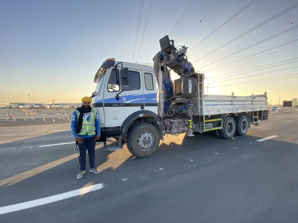A Pole Star team member beside a Mercedes crane truck.